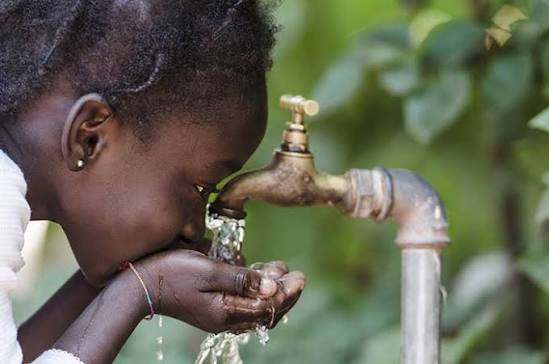 Child drinking clean water from a community tap