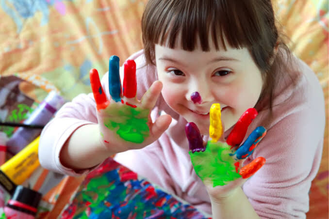 Child with disability enjoying creative play with paint