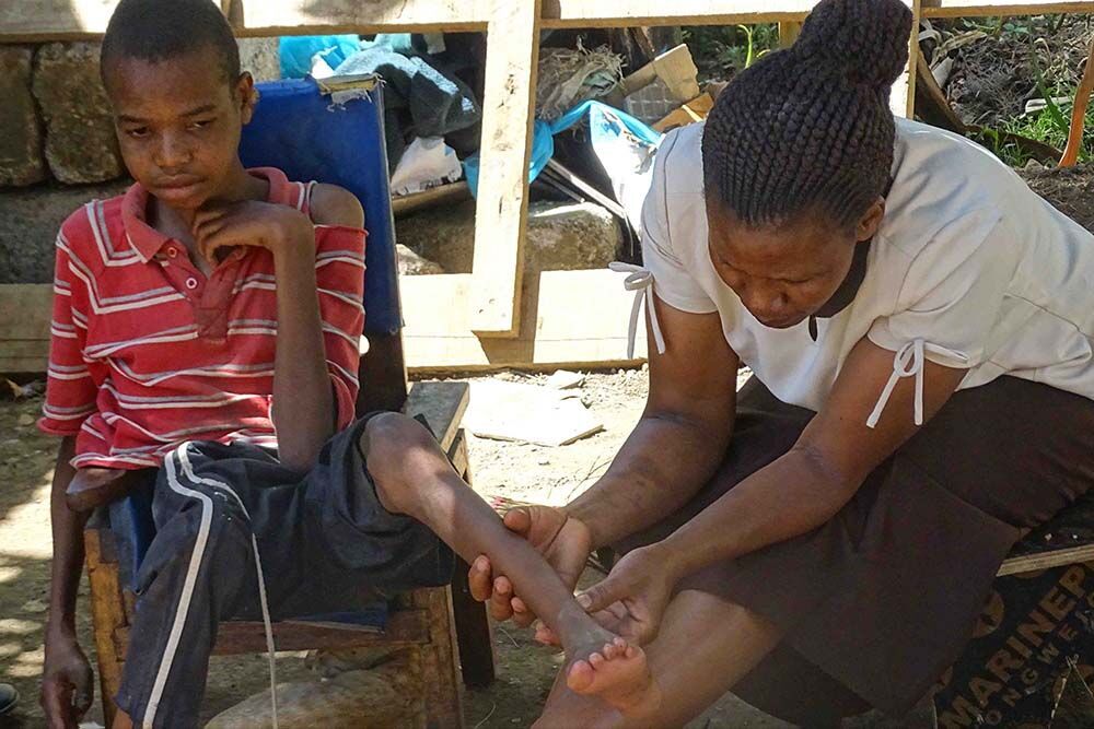 Caregiver providing physical support to a child with disability