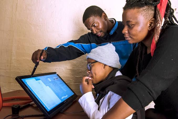 Mentors guiding a student on a digital tablet